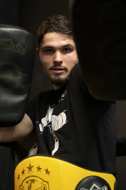 Casper Boekee kijkt tussen opgeheven Thai pads door