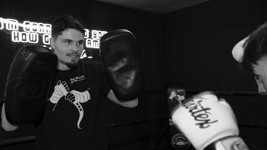 Casper Boekee met Thai pads in de ring, in zwart-wit