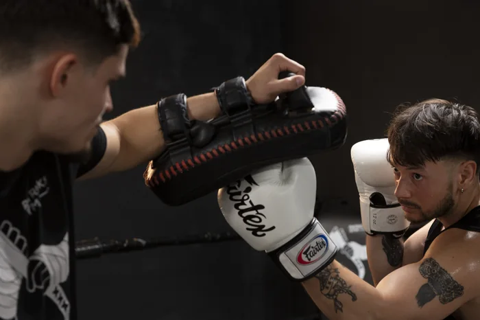 Close-up of a glove landing on a Thai pad