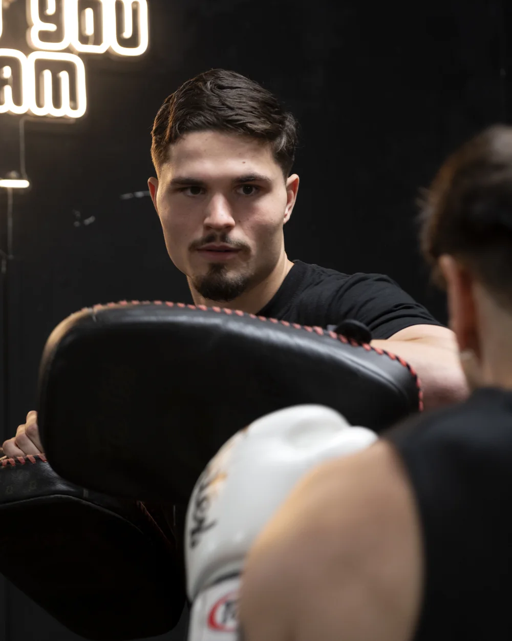 Casper Boekee holding Thai pads for a client in the ring at Patrick's Gym